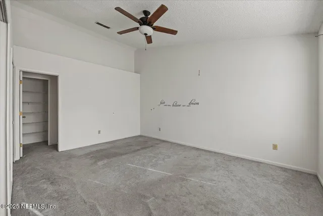 an empty room with a ceiling fan and a window