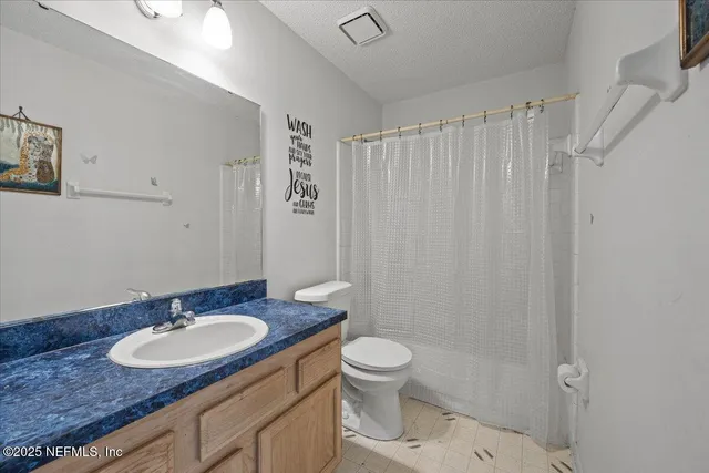 a bathroom with a granite countertop sink toilet a mirror and shower