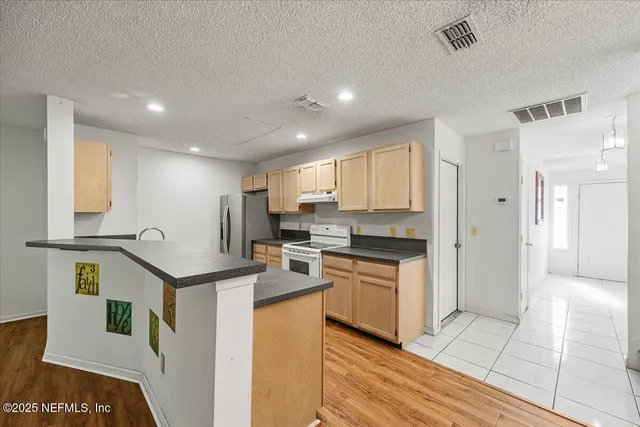 a kitchen with stainless steel appliances granite countertop a stove a sink and a refrigerator