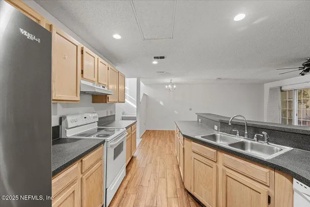 a kitchen with granite countertop a sink stove and cabinets