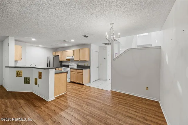 a view of kitchen with granite countertop cabinets and refrigerator