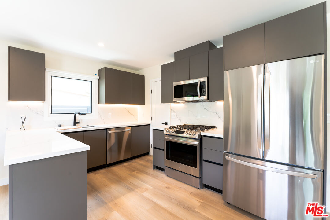 842 North Alfred Street, Unit 1 Los Angeles, CA 90069 - Photo 2 of 14 a kitchen with a refrigerator stove and sink