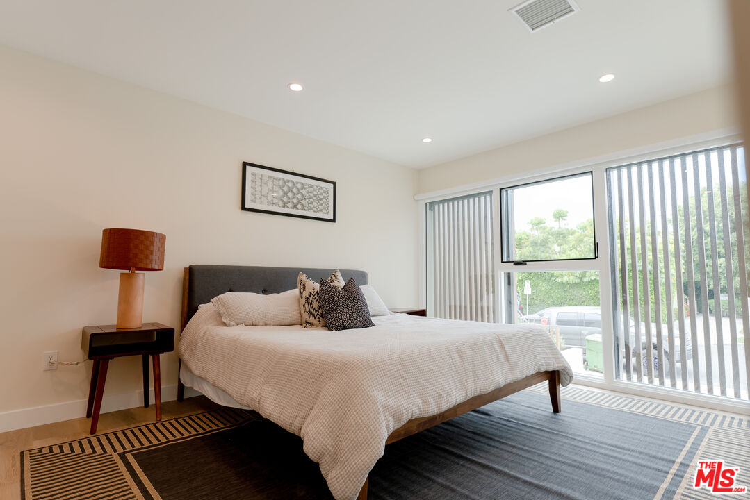842 North Alfred Street, Unit 1 Los Angeles, CA 90069 - Photo 8 of 14 a bedroom with a bed and a lamp next to a window