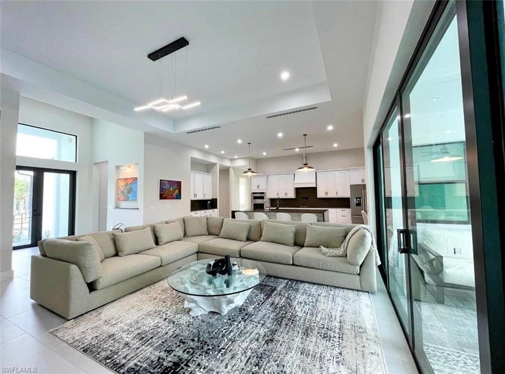 687 23rd Street Southwest Naples, FL 34117 - Photo 12 of 40 Living area with a raised ceiling, recessed lighting, and french doors