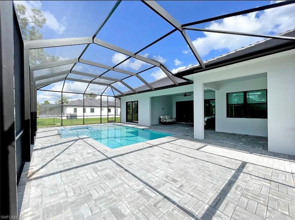 687 23rd Street Southwest Naples, FL 34117 - Photo 15 of 40 Outdoor pool featuring a sunroom, a lanai, and a patio area