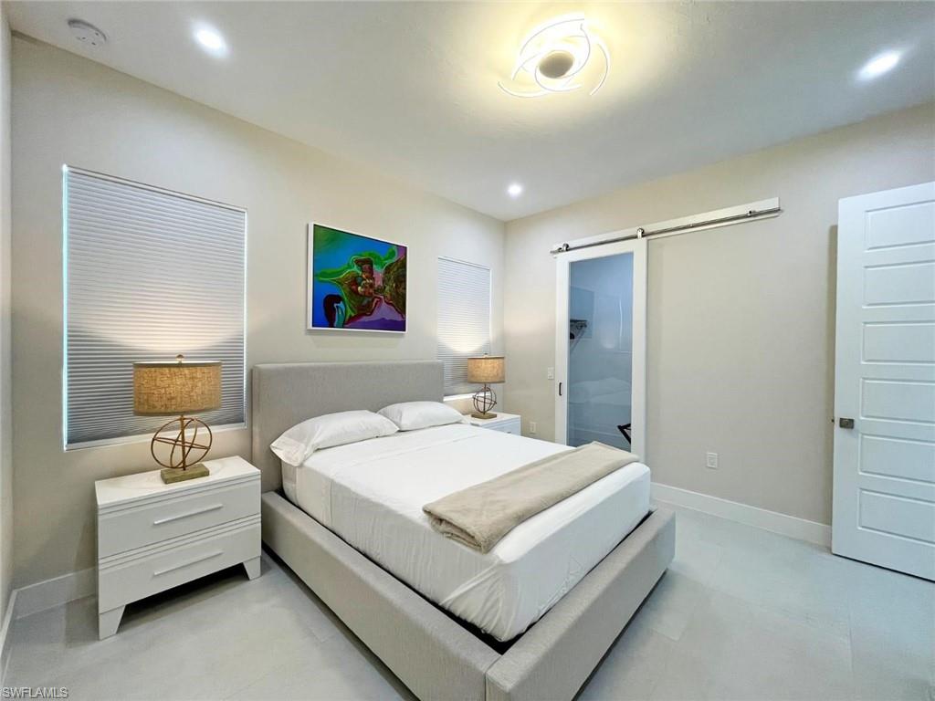 687 23rd Street Southwest Naples, FL 34117 - Photo 22 of 40 Bedroom with a barn door, recessed lighting, and ensuite bathroom