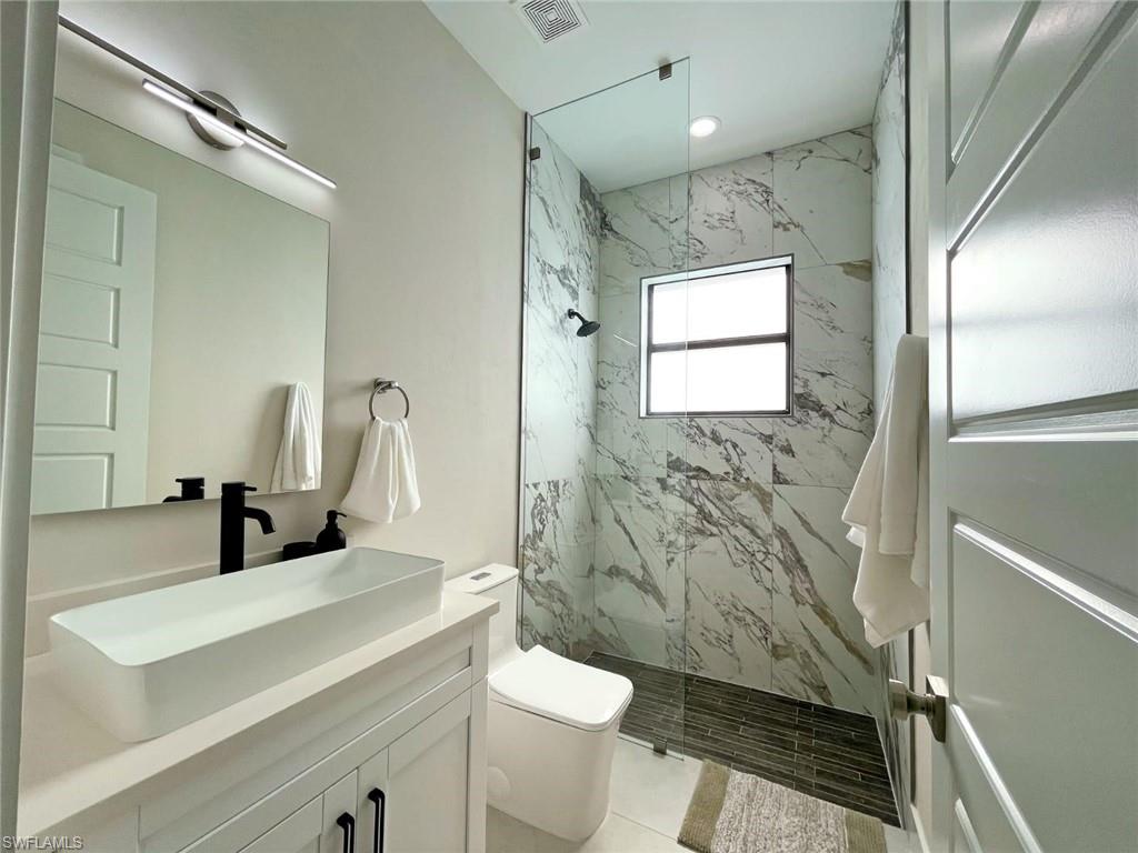 687 23rd Street Southwest Naples, FL 34117 - Photo 24 of 40 Bathroom with a marble finish shower and vanity