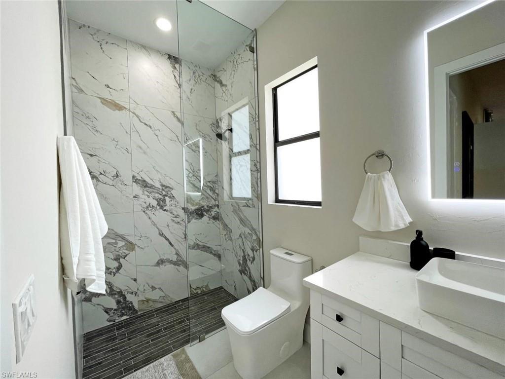 687 23rd Street Southwest Naples, FL 34117 - Photo 28 of 40 Bathroom with vanity and a marble finish shower