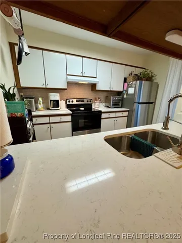 a kitchen with stainless steel appliances granite countertop a sink a stove and a refrigerator