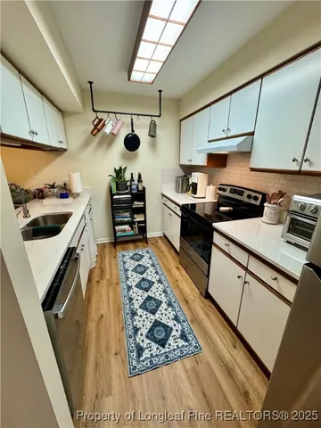 a kitchen with stainless steel appliances granite countertop a stove and a sink