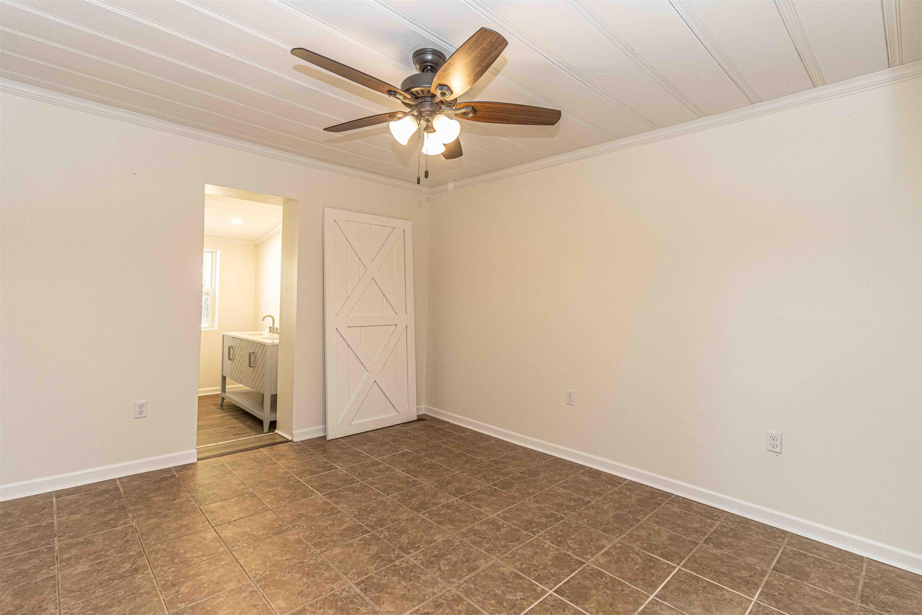 212 North Maple Street Adamsville, TN 38310 - Photo 11 of 25 an empty room with a chandelier fan and windows