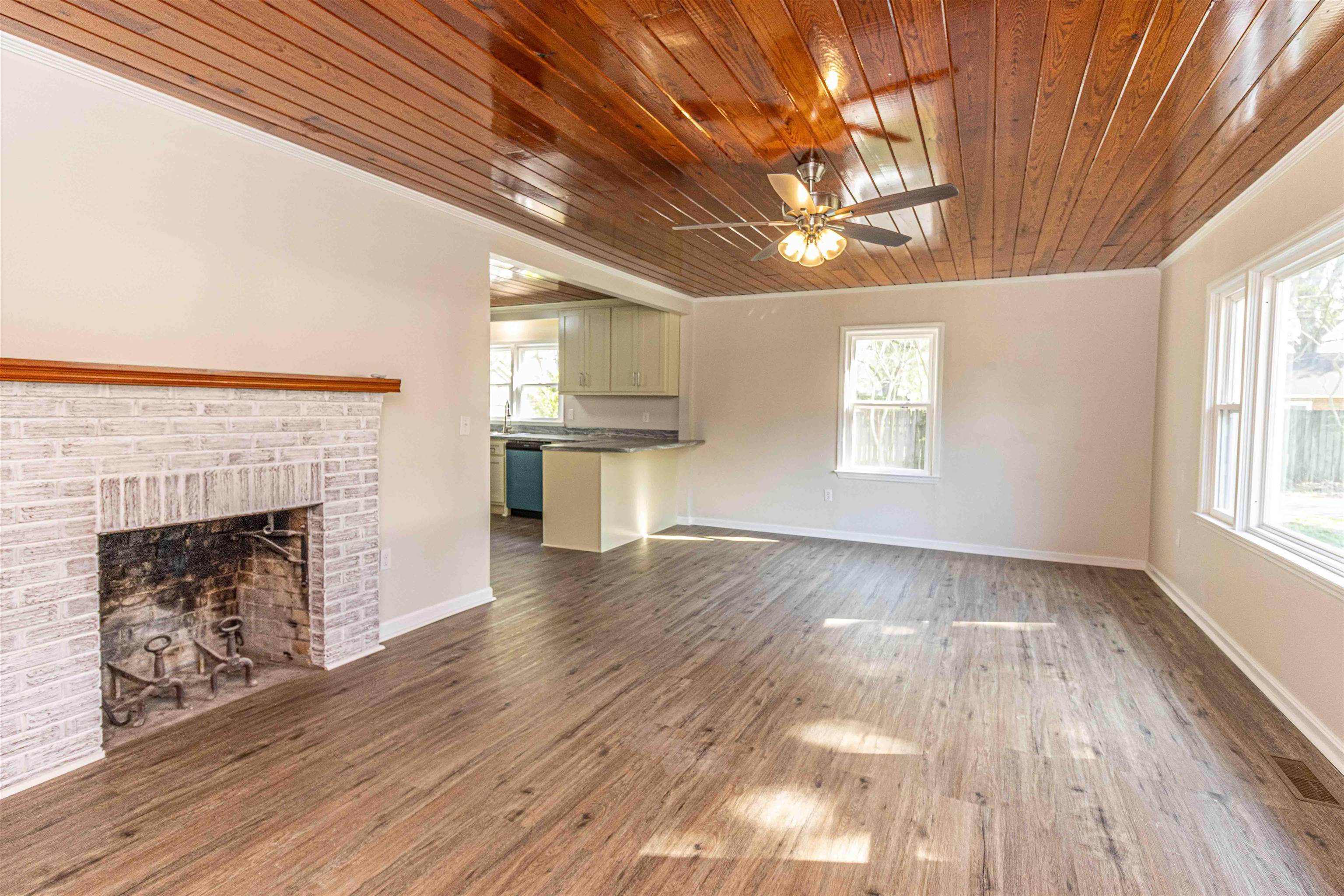 212 North Maple Street Adamsville, TN 38310 - Photo 4 of 25 a view of empty room with wooden floor and fireplace