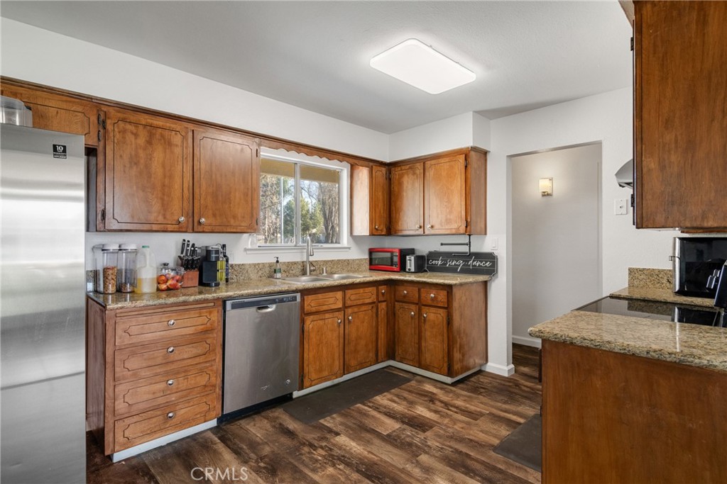 3157 Juneau Court Merced, CA 95348 - Photo 12 of 26 a kitchen with granite countertop wooden cabinets stainless steel appliances a sink and a window