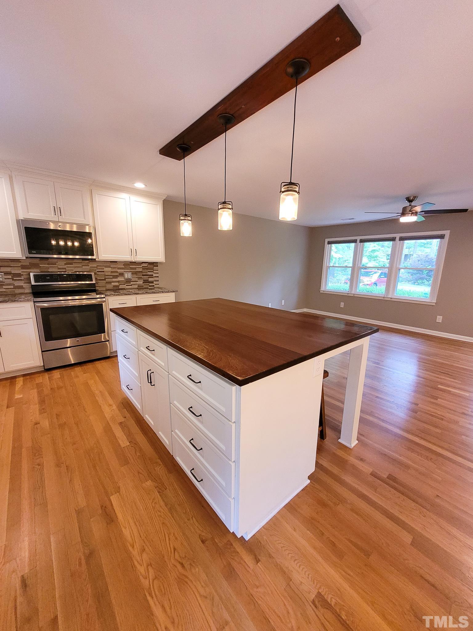 6708 Johnsdale Road Raleigh, NC 27615 - Photo 11 of 44 a kitchen with stainless steel appliances granite countertop a stove a sink and a wooden floors