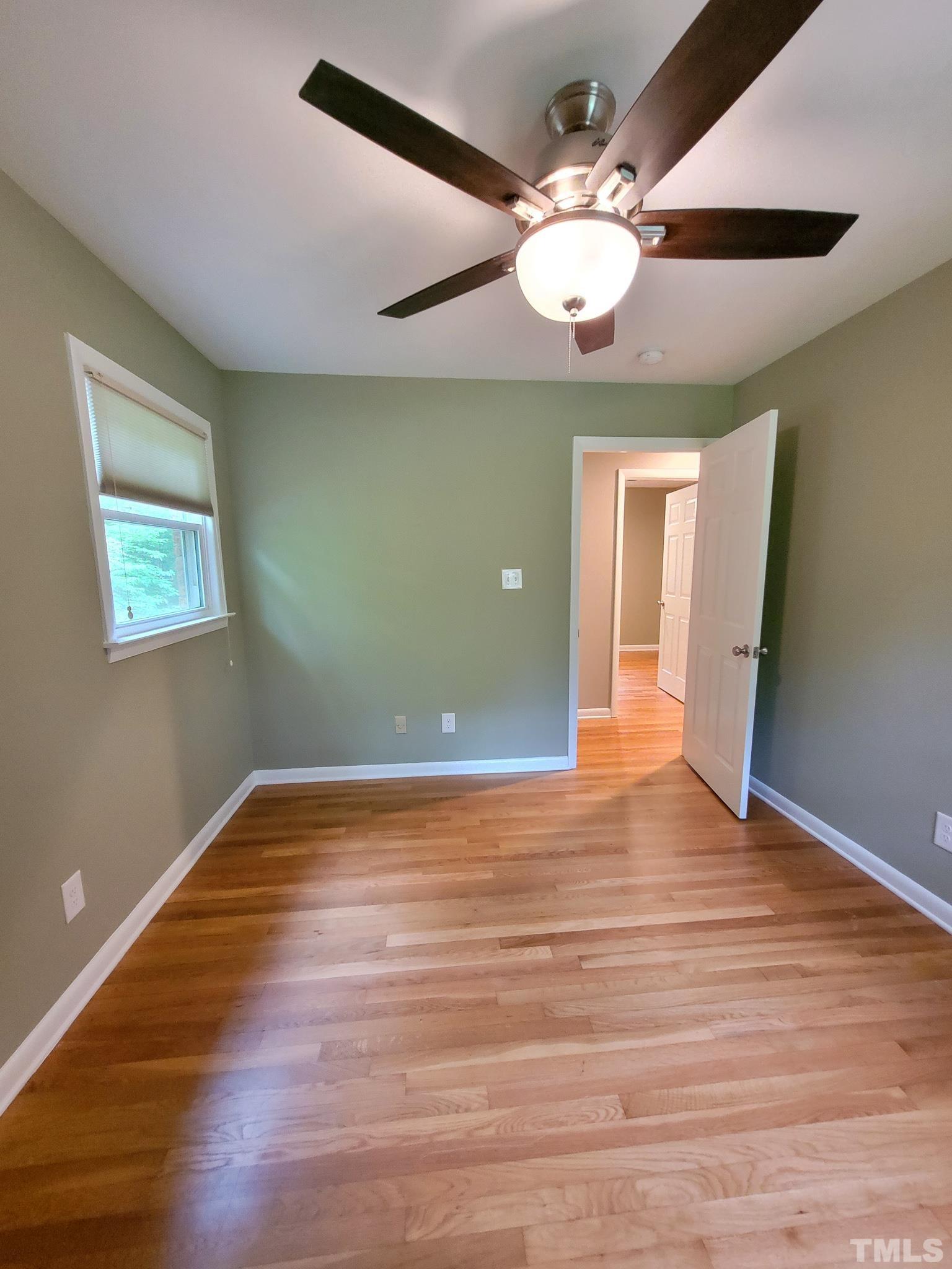 6708 Johnsdale Road Raleigh, NC 27615 - Photo 29 of 44 a view of an empty room with wooden floor and a ceiling fan
