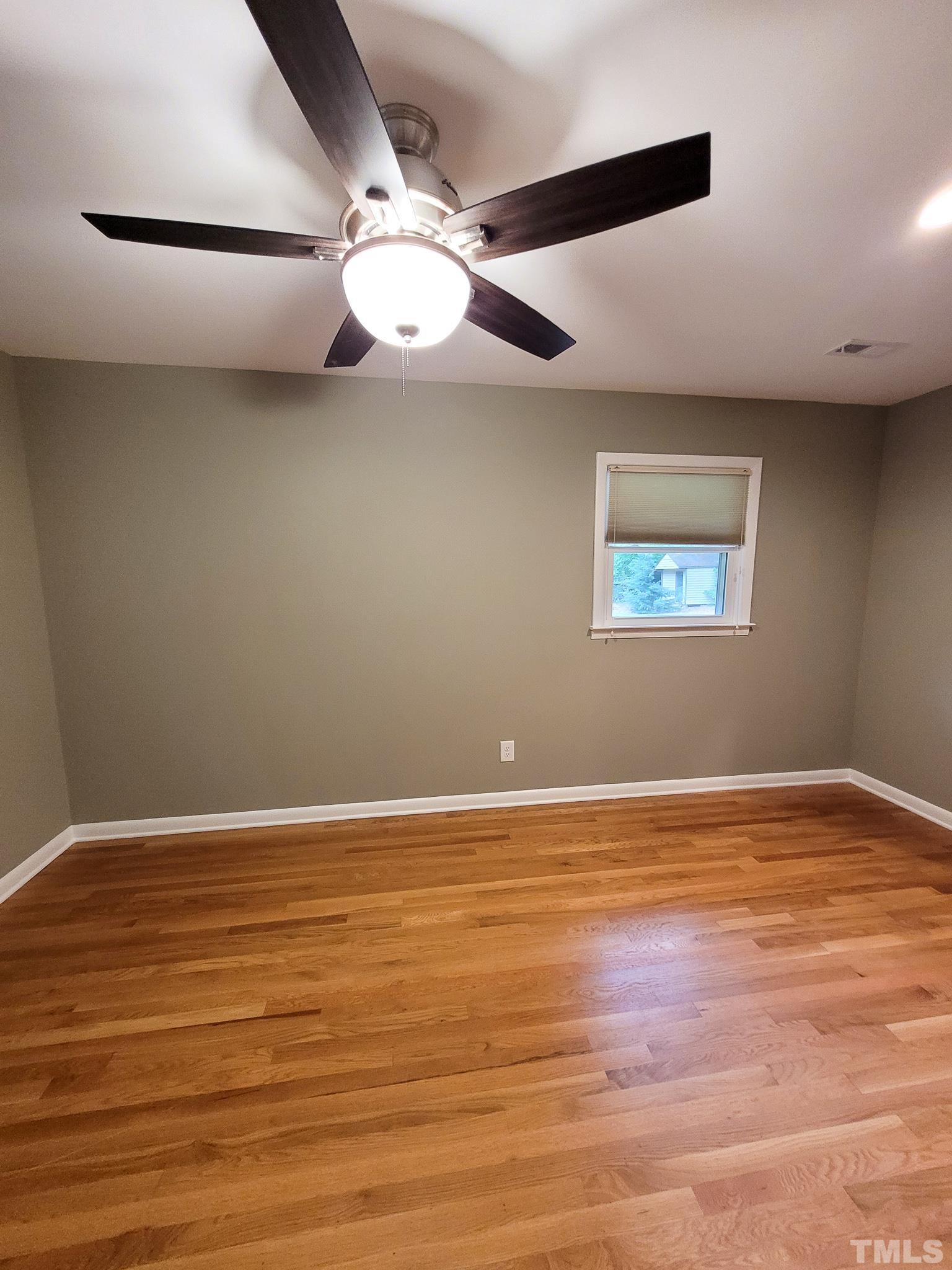 6708 Johnsdale Road Raleigh, NC 27615 - Photo 33 of 44 an empty room with wooden floor and windows