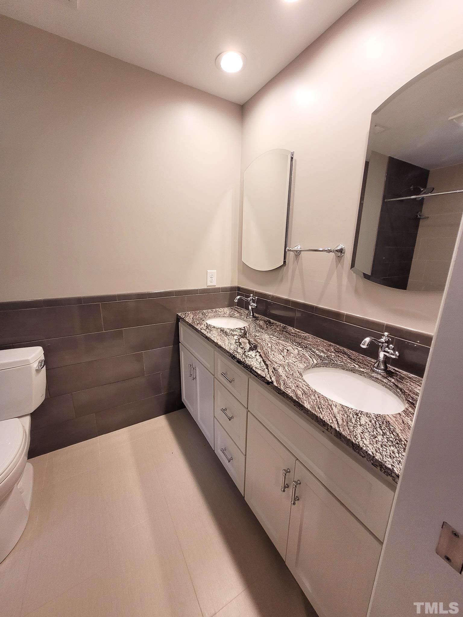 6708 Johnsdale Road Raleigh, NC 27615 - Photo 38 of 44 a spacious bathroom with a granite countertop sink and a mirror