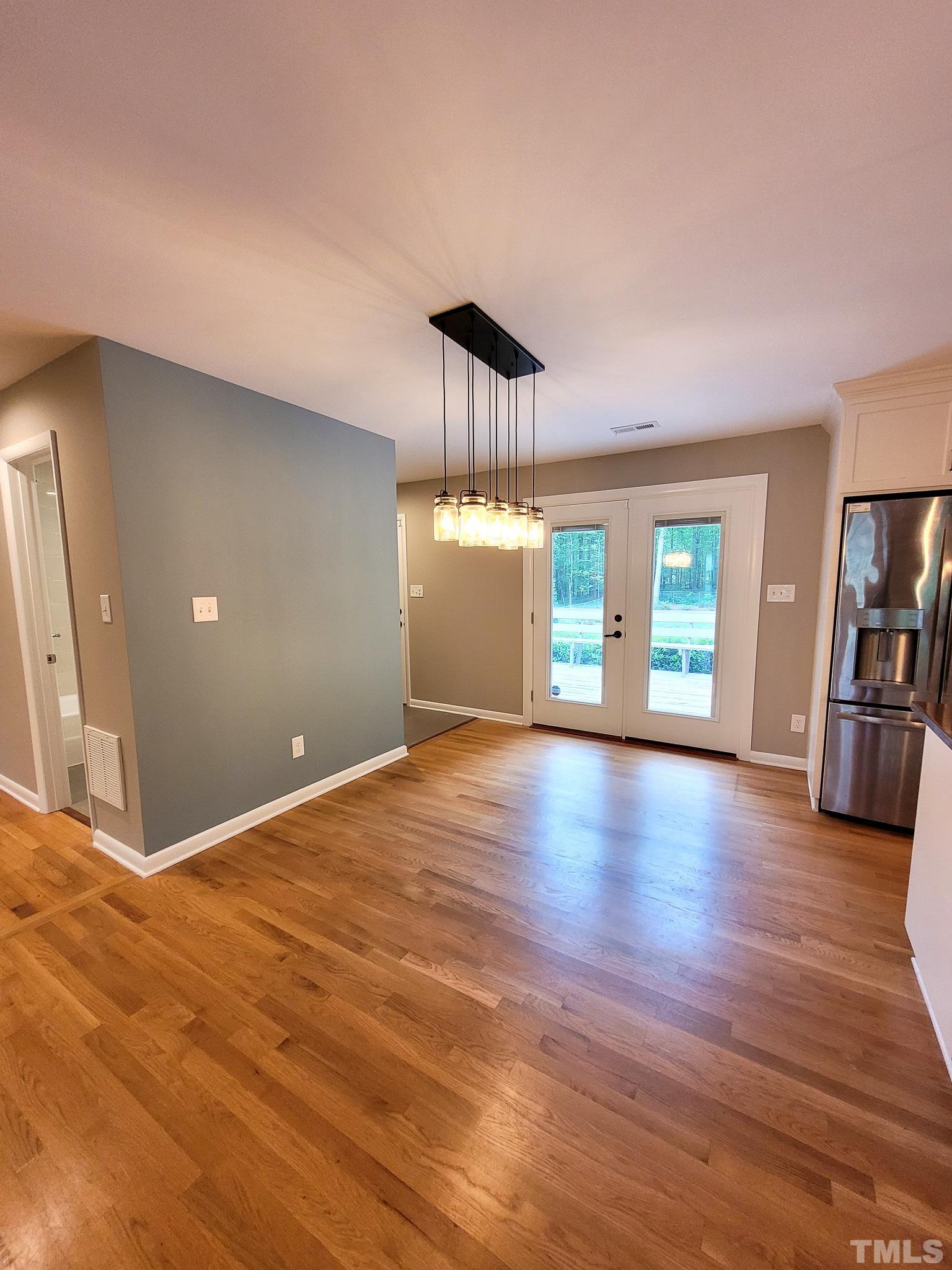 6708 Johnsdale Road Raleigh, NC 27615 - Photo 9 of 44 a view of an empty room with window and wooden floor