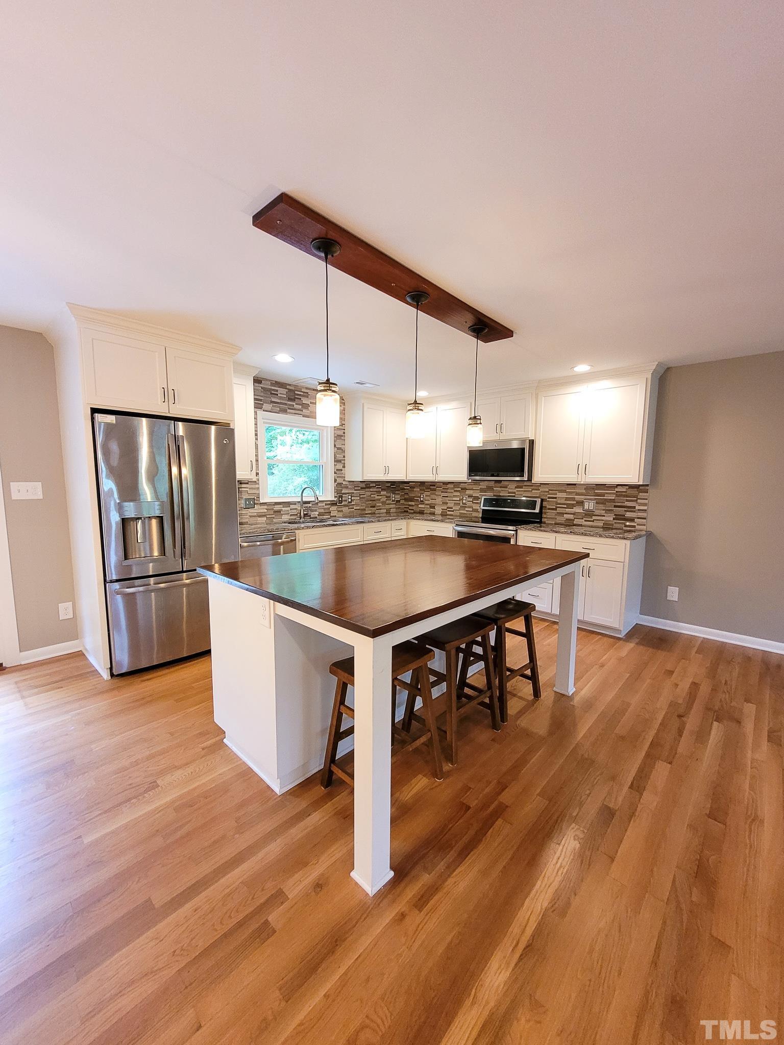 6708 Johnsdale Road Raleigh, NC 27615 - Photo 10 of 44 a kitchen with stainless steel appliances granite countertop a stove top oven a sink a counter space and cabinets