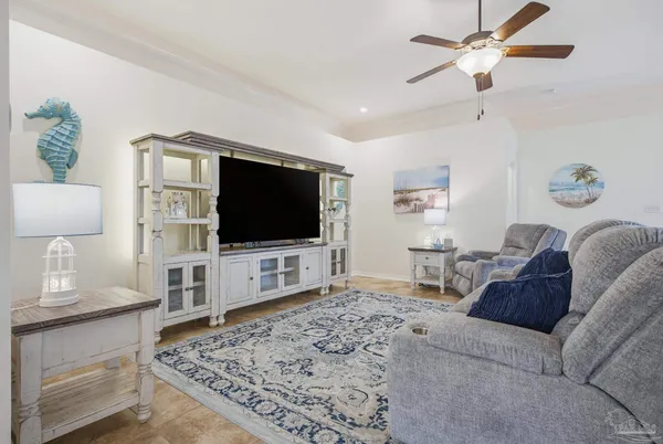 a living room with furniture ceiling fan and a rug