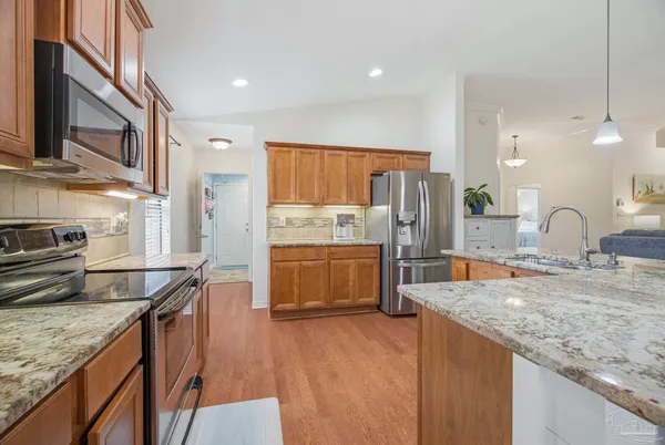 a kitchen with stainless steel appliances granite countertop a sink a counter space and cabinets