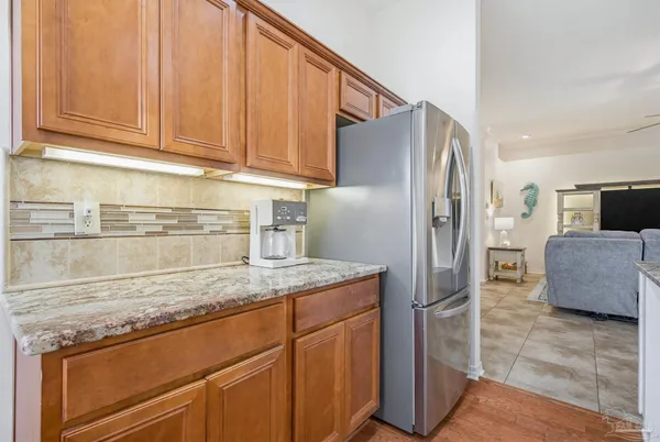 a kitchen with granite countertop a refrigerator stove top oven and sink