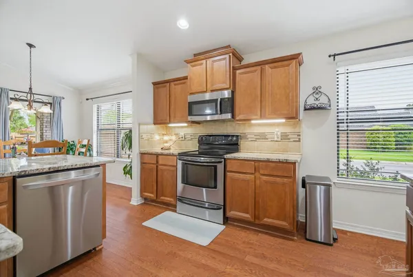 a kitchen with stainless steel appliances granite countertop wooden floors and granite counter tops