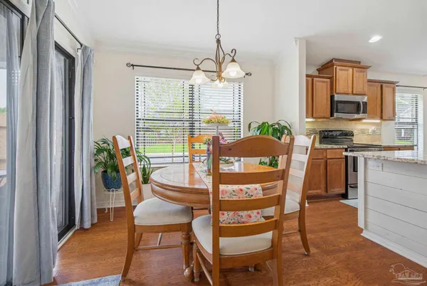a dining room with furniture potted plants and wooden floor