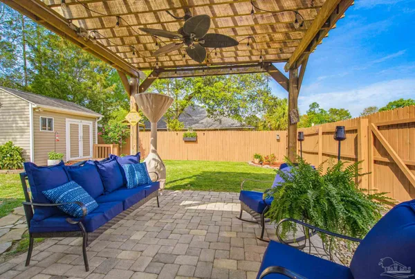 a backyard of a house with plants and large tree