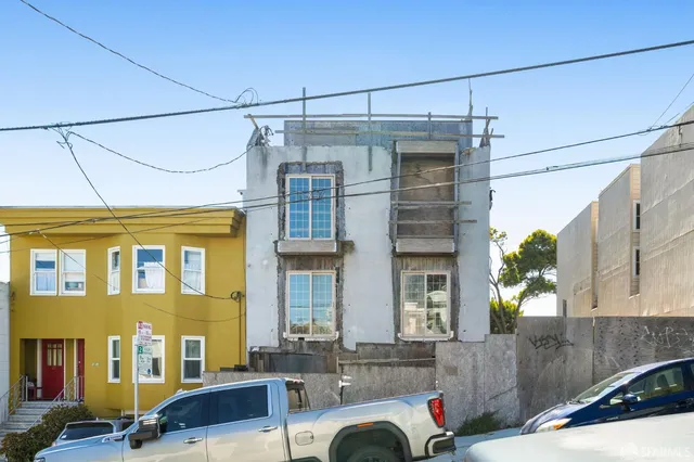 a view of a house with a cars park side of a street