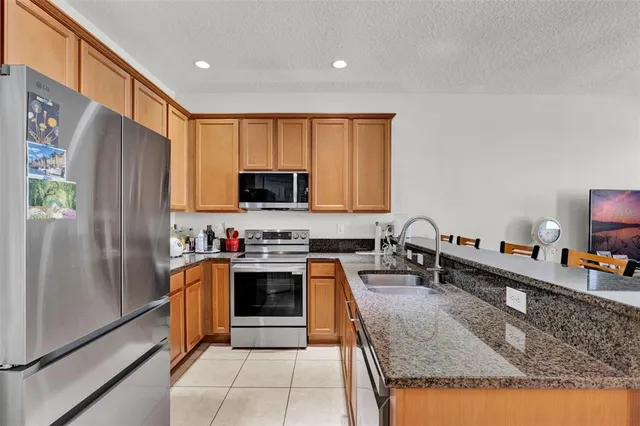 a kitchen with stainless steel appliances granite countertop a refrigerator stove and sink