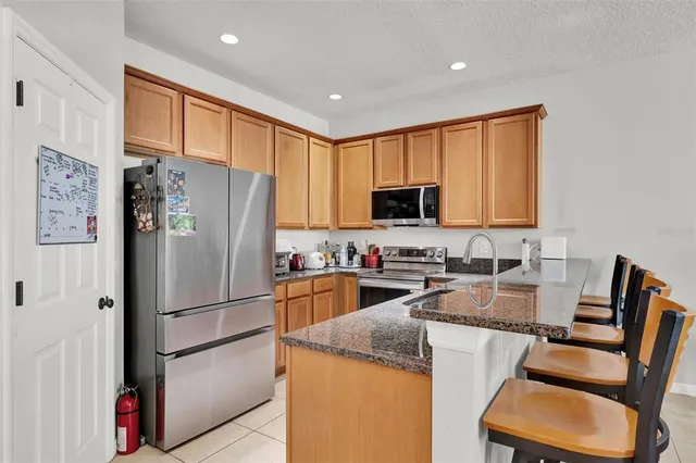 a kitchen with stainless steel appliances granite countertop a refrigerator stove microwave and sink