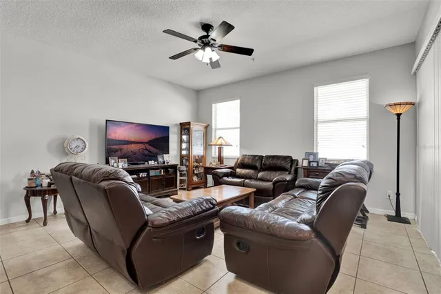 a living room with furniture a chandelier and a flat screen tv