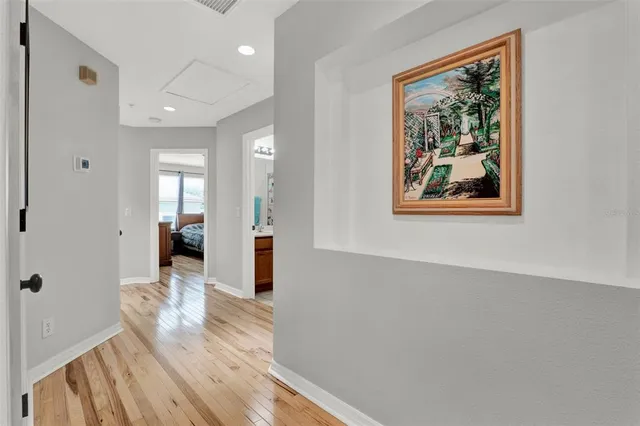 a view of a hallway with wooden floor and a living room