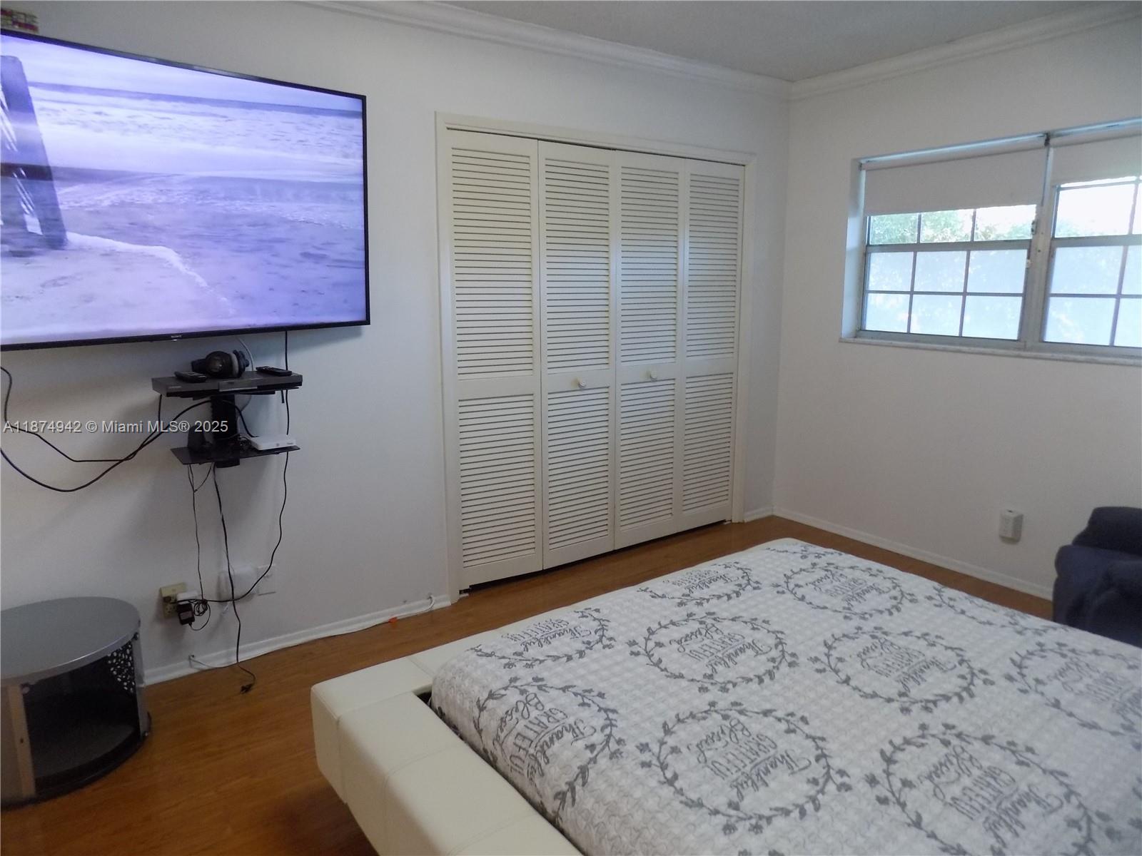 3100 North Course Lane, Unit 502 Pompano Beach, FL 33069 - Photo 20 of 32 a view of a room with a bed and wooden floor