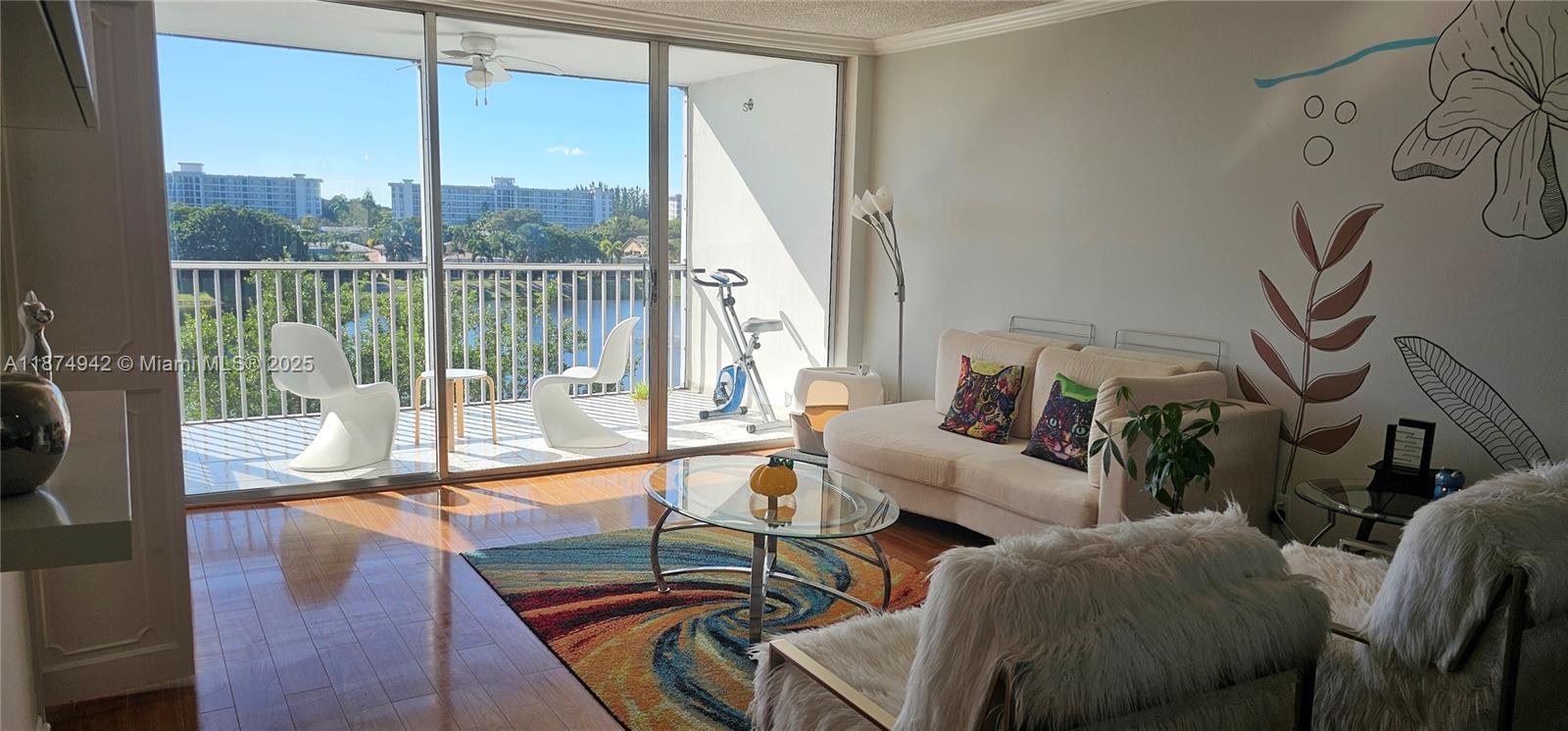 3100 North Course Lane, Unit 502 Pompano Beach, FL 33069 - Photo 2 of 32 a living room with furniture and a floor to ceiling window