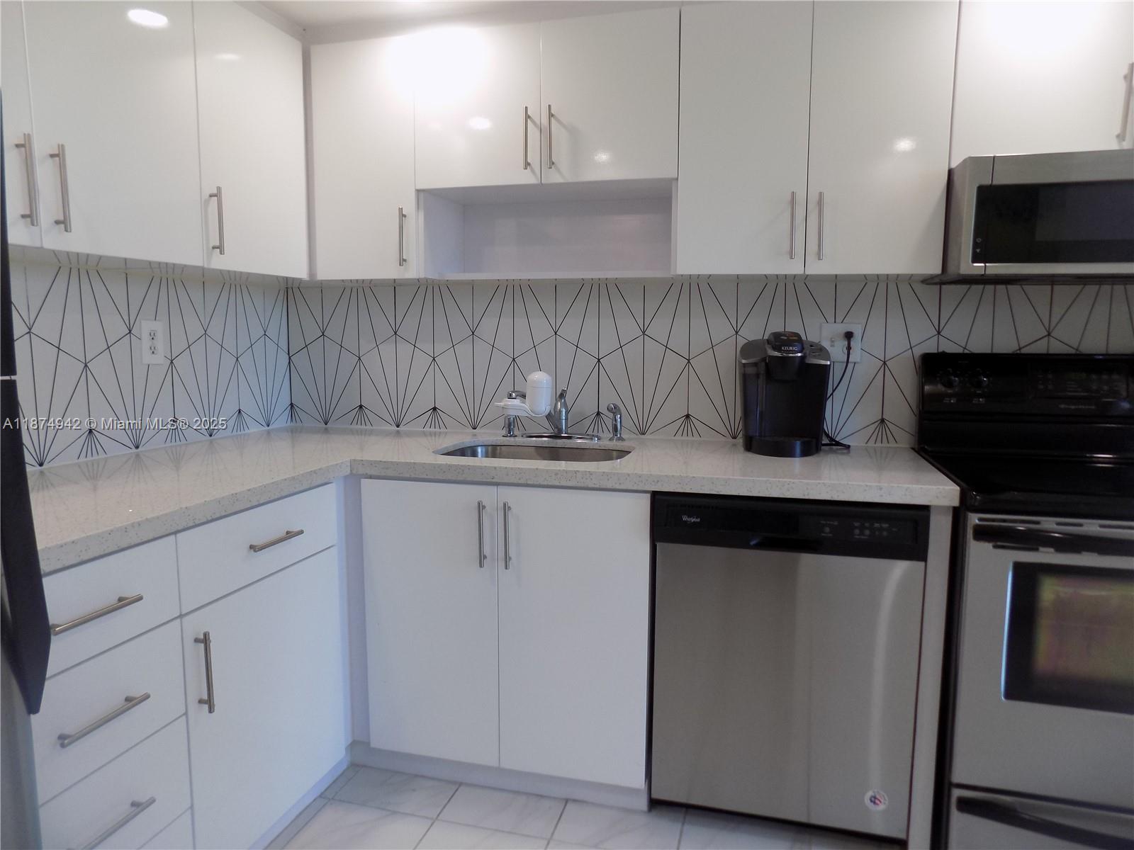 3100 North Course Lane, Unit 502 Pompano Beach, FL 33069 - Photo 27 of 32 a kitchen with a sink and a stove top oven