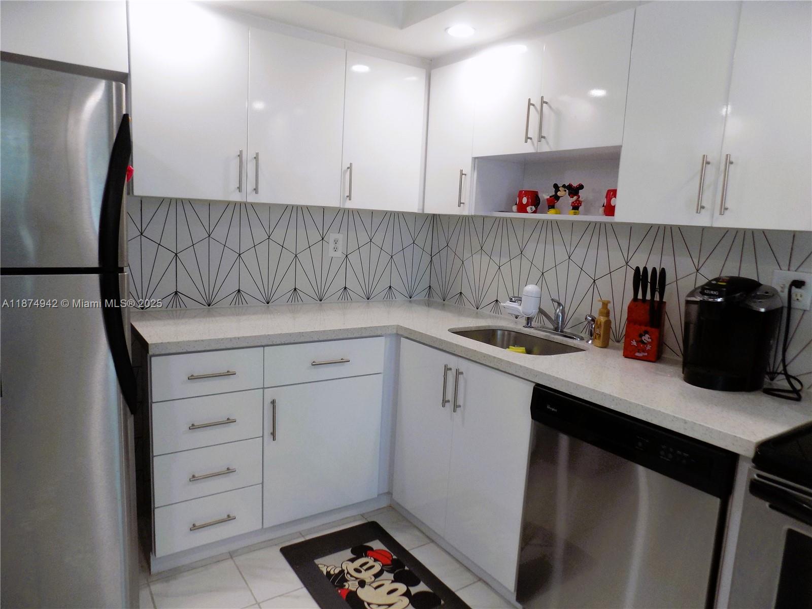 3100 North Course Lane, Unit 502 Pompano Beach, FL 33069 - Photo 28 of 32 a kitchen with a sink and cabinets