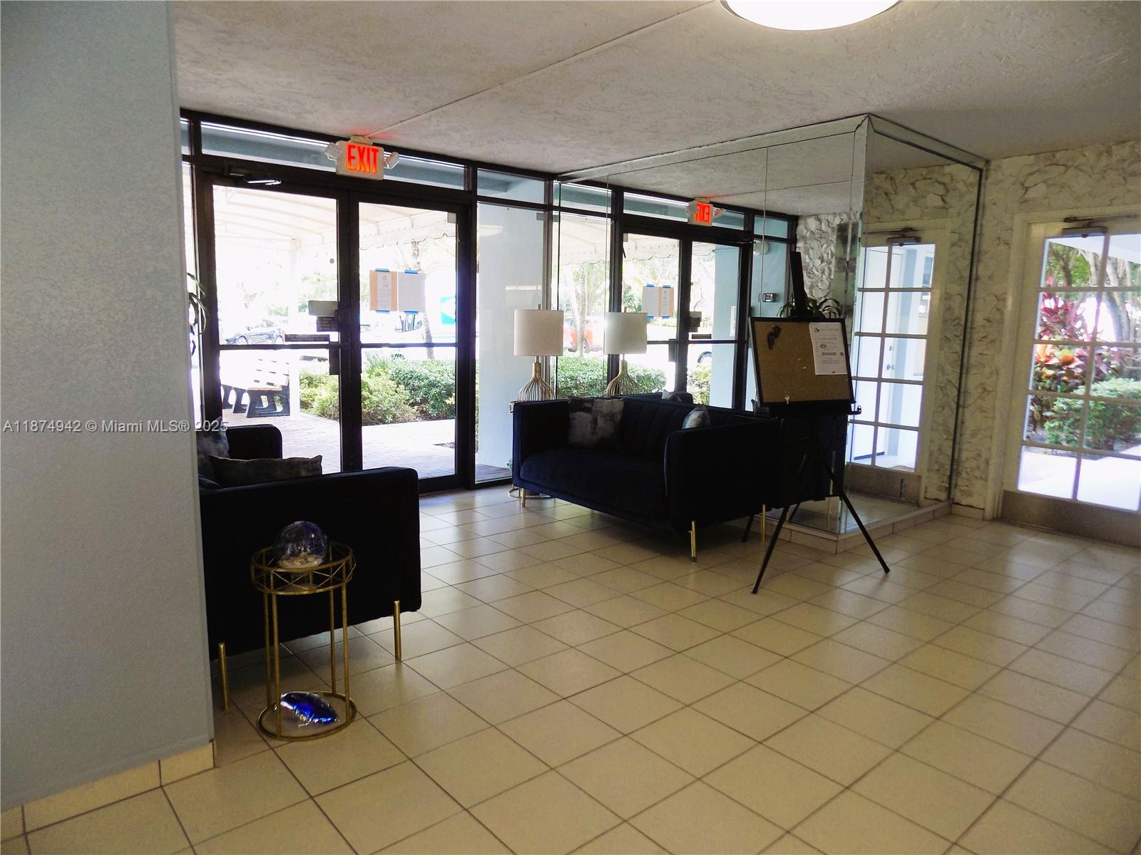 3100 North Course Lane, Unit 502 Pompano Beach, FL 33069 - Photo 10 of 32 a living room with furniture and a floor to ceiling window