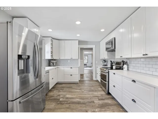 a kitchen with refrigerator and chairs