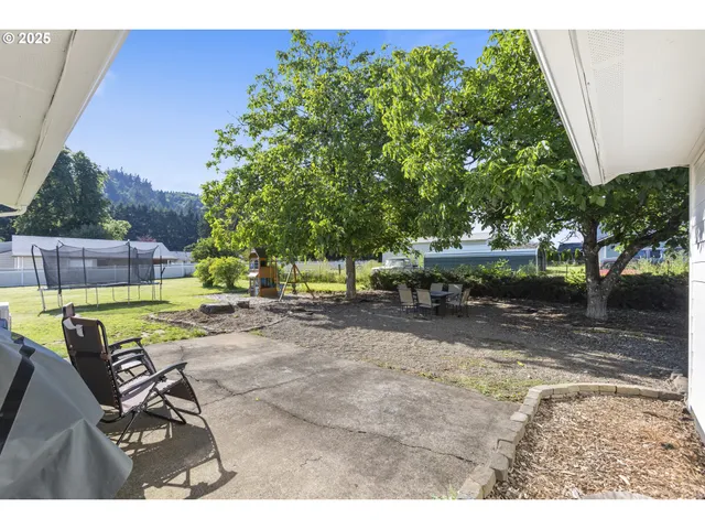 a view of a house with backyard and a sitting area