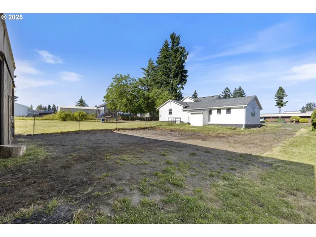 a view of a house with backyard and tree
