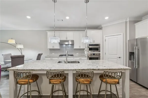 a kitchen with stainless steel appliances kitchen island granite countertop a stove a sink and a refrigerator