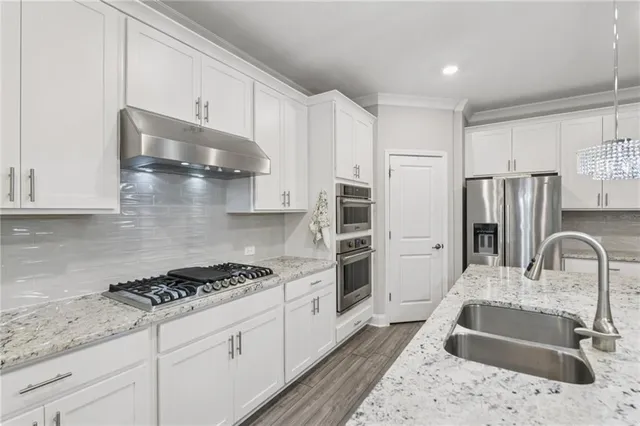 a kitchen with stainless steel appliances granite countertop a sink stove and refrigerator