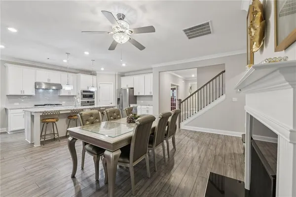 a living room with lots of furniture kitchen view and a chandelier