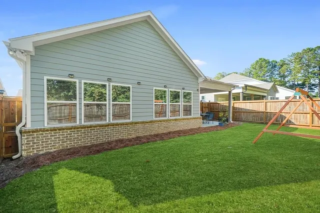 a view of backyard with table and chairs and a large tree