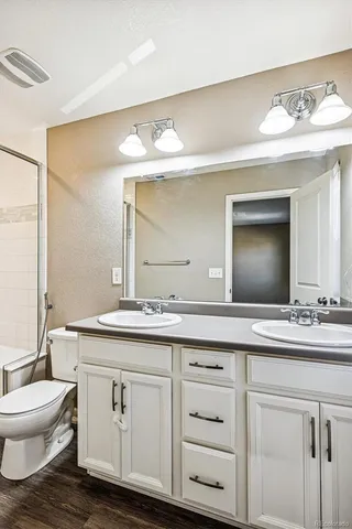 a bathroom with a toilet sink and mirror