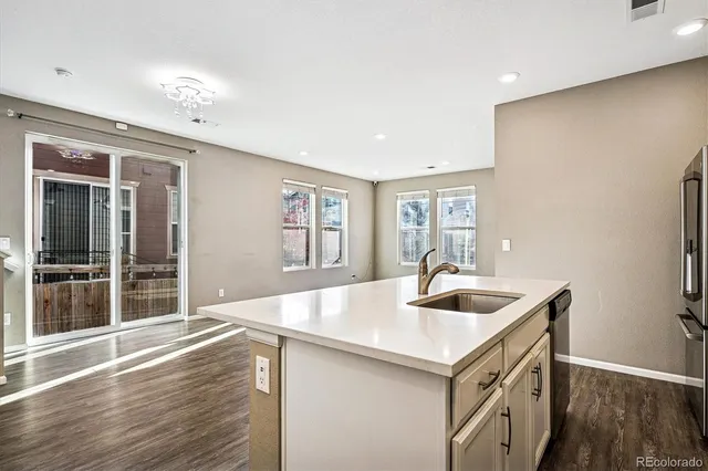 a kitchen with stainless steel appliances granite countertop a sink and a wooden floors