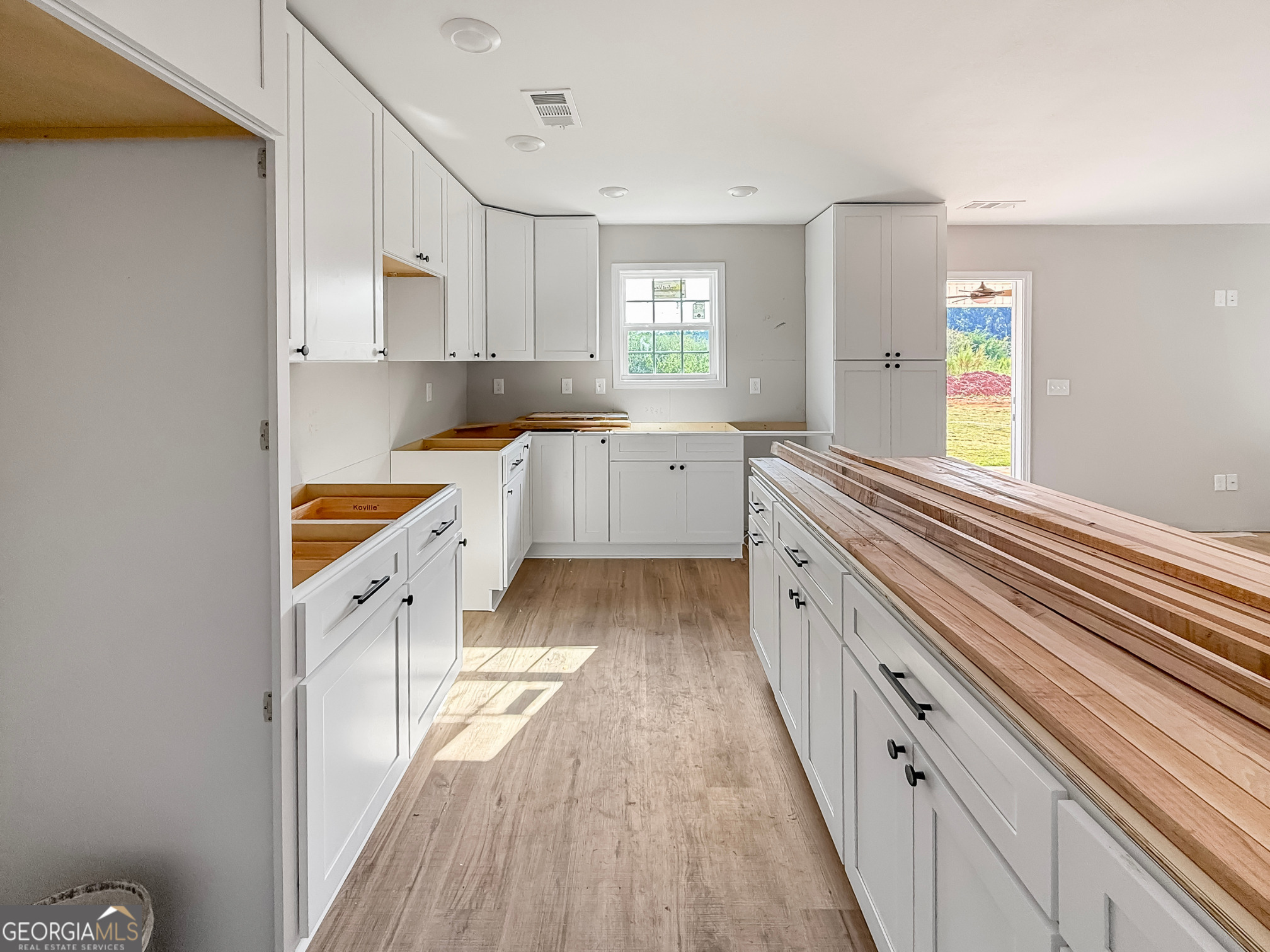 206 Sutton Drive Perry, GA 31069 - Photo 4 of 27 a large kitchen with a white cabinets and wooden floor
