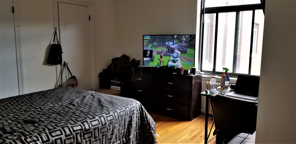 14 Ashland Street, Unit 2R Worcester, MA 01609 - Photo 13 of 16 a bedroom with a bed and a flat tv screen